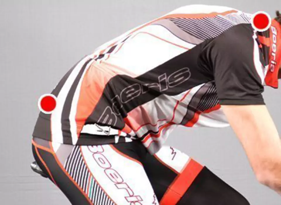 il particolare di una schiena di un ciclista con due punti rossi per spiegare la giusta postura in sella e non avere mal di schiena in bici
