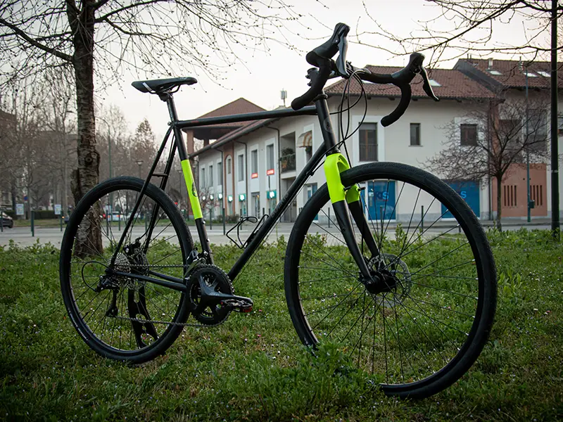 Gravel bike serie X color nera e giallo fluo con sella e manubrio neri di Boeris Bikes Torino in mezzo ad un parco cittadino