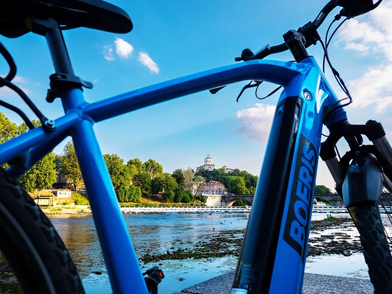 e bike e-mtb lumina blu di Boeris Bike Torino fotografata sul lungo Po con sullo sfondo Chiesa di Santa Maria del Monte dei Cappuccini