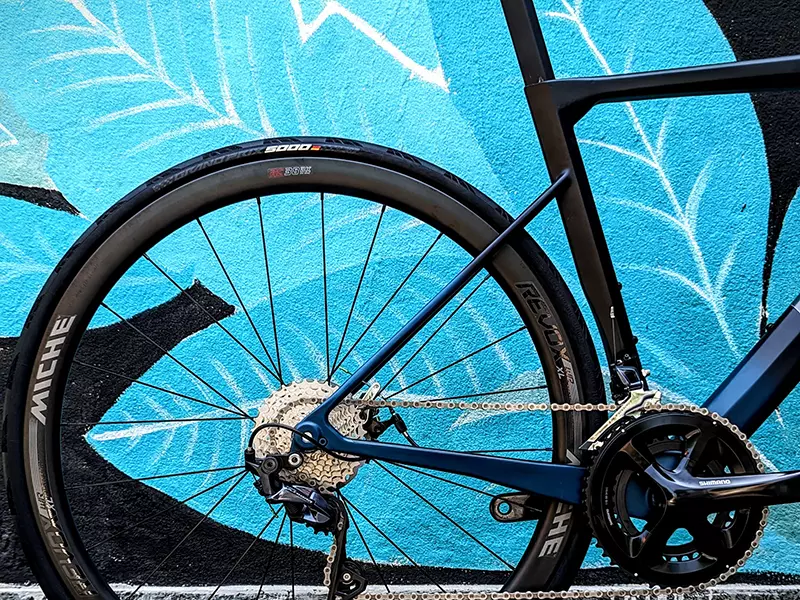 dettaglio posteriore Bici da strada Nordend Boeris Bikes Torino Nera e Blu appoggiata ad un murales azzurro