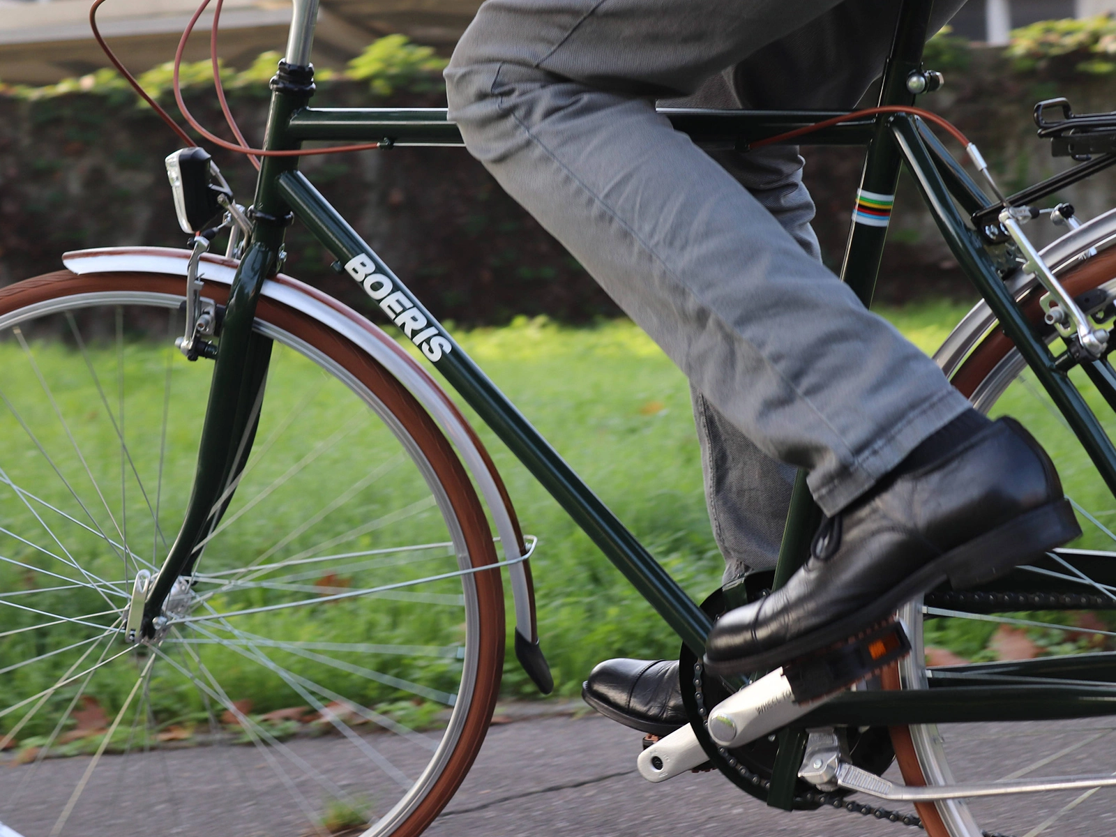 Fotografia ravvicinata di una city bike retrò colore verdone e marrone di Boeris Bikes Torino in un parco cittadino