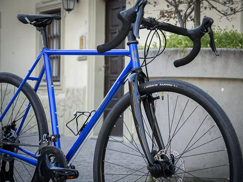 Una gravel serie x blu Boeris Bikes Torino vicino ad una fioriera