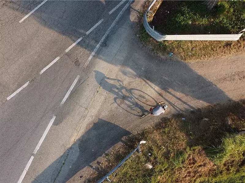 ripresa dall'alto di un ciclista in sella ad una gravel x-performance Boeris Bikes torino mentre imbocca una strada sterrata 