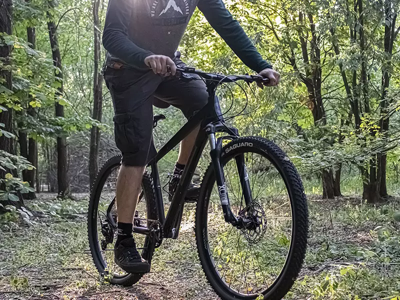 Ragazzo in sella alla sua MTB Volcano nera Boeris Bikes Torino in mezzo ad un bosco