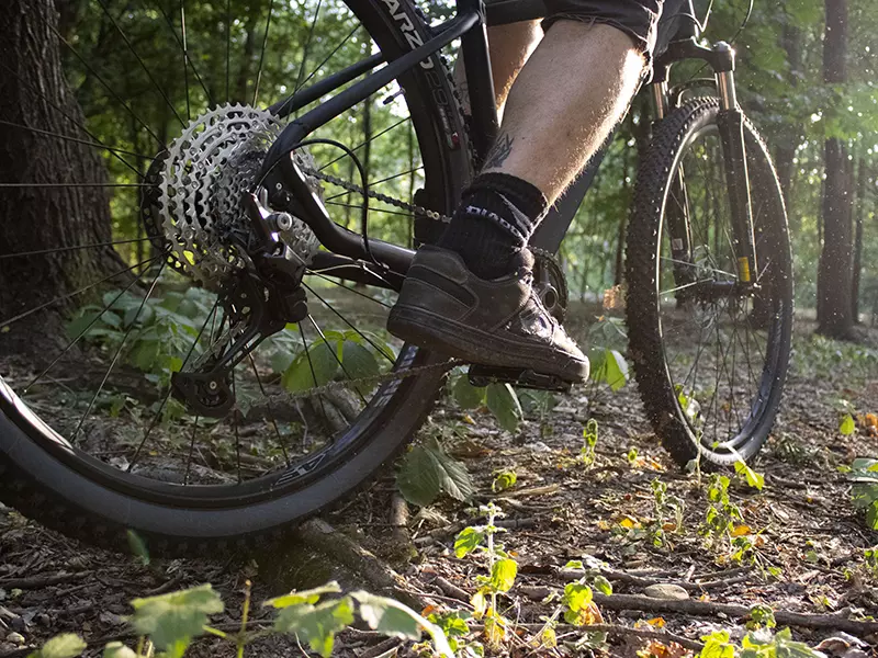 Ragazzo in sella alla sua MTB Volcano nera Boeris Bikes Torino in mezzo ad un bosco