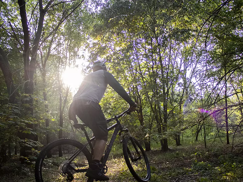 Ragazzo con caschetto in sella alla sua MTB Volcano nera Boeris Bikes Torino in mezzo ad un bosco