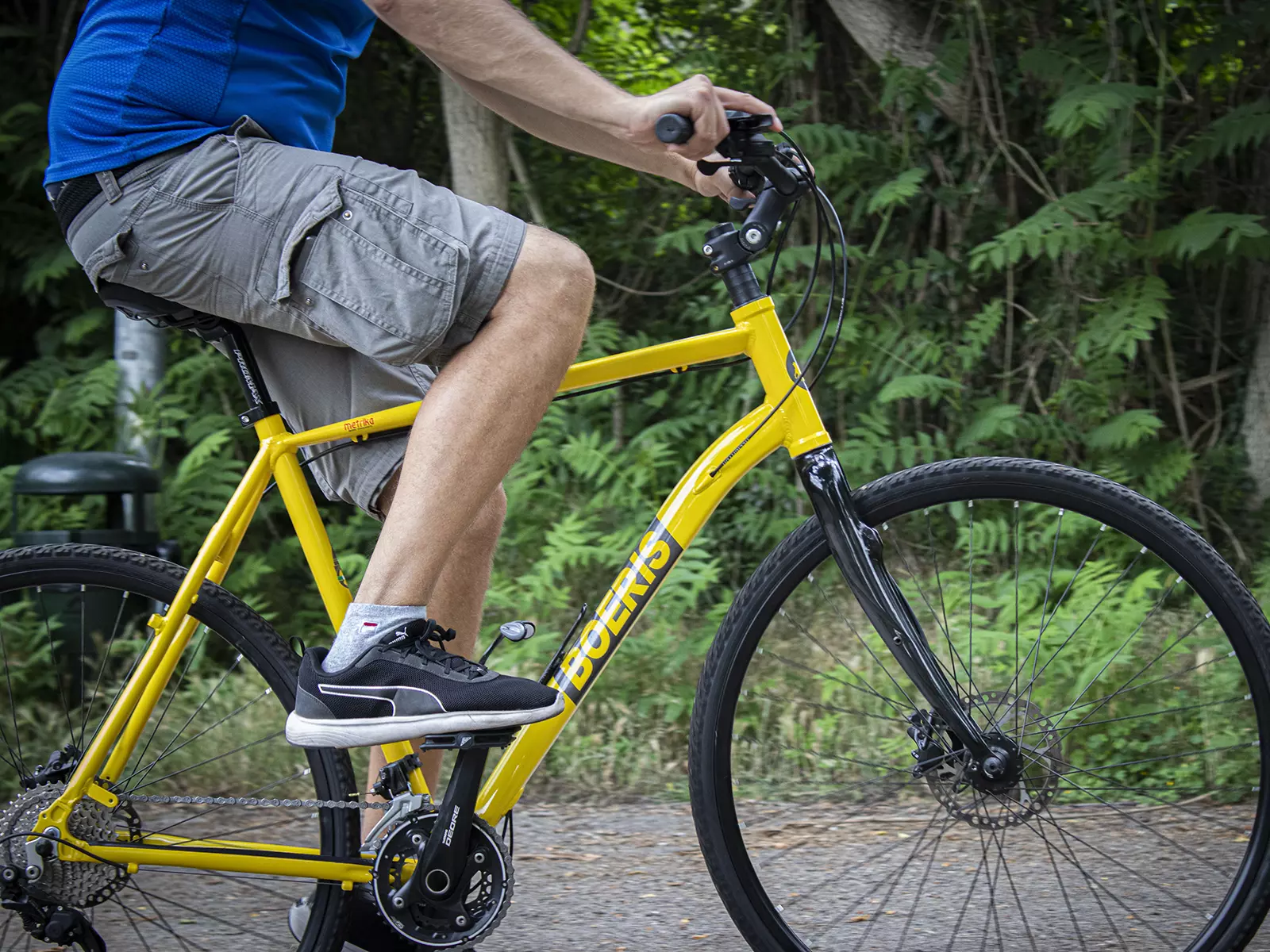 Ragazzo in sella ad una Trekking Bike Boeris Bike Torino gialla in un parco cittadino