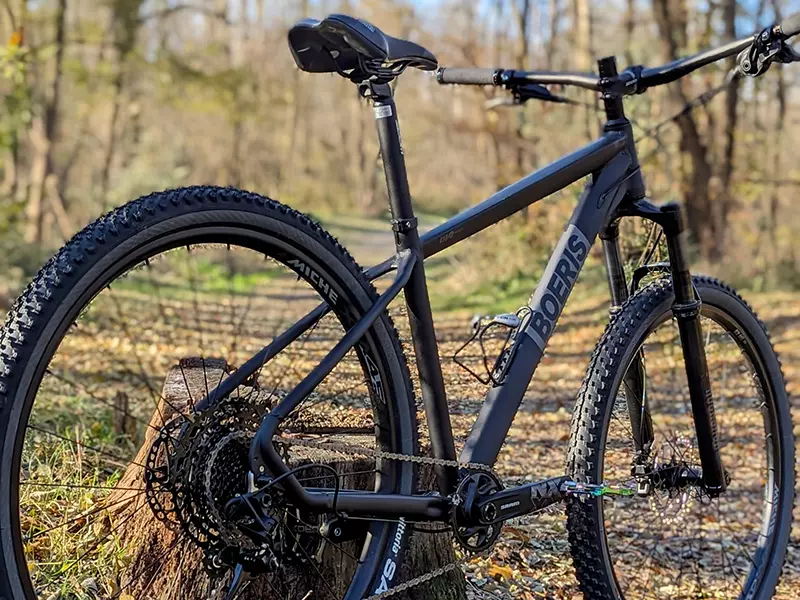 MTB Volcano Pro di Boeris Bikes nera Torino fotografata in un bosco appoggiata ad un tronco