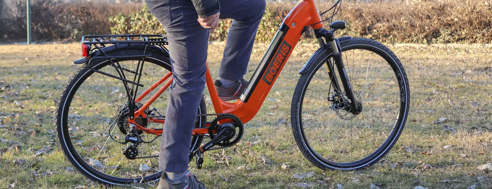 Ebike E-trekking Puma Boeris Bikes Torino Arancione fotografata in mezzo ad un parco cittadino