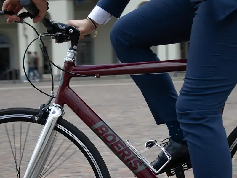 dettaglio City Bike business color amaranto di boeris Bikes Torino guidata in una piazza di Torino