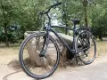 Fotografia di una city bike urban travel nera di Boeris Bikes Torino appoggiata su una roccia in un parco cittadino