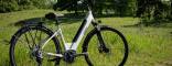 Ebike E-trekking Puma Boeris Bikes Torino Arancione fotografata in mezzo ad un parco cittadino