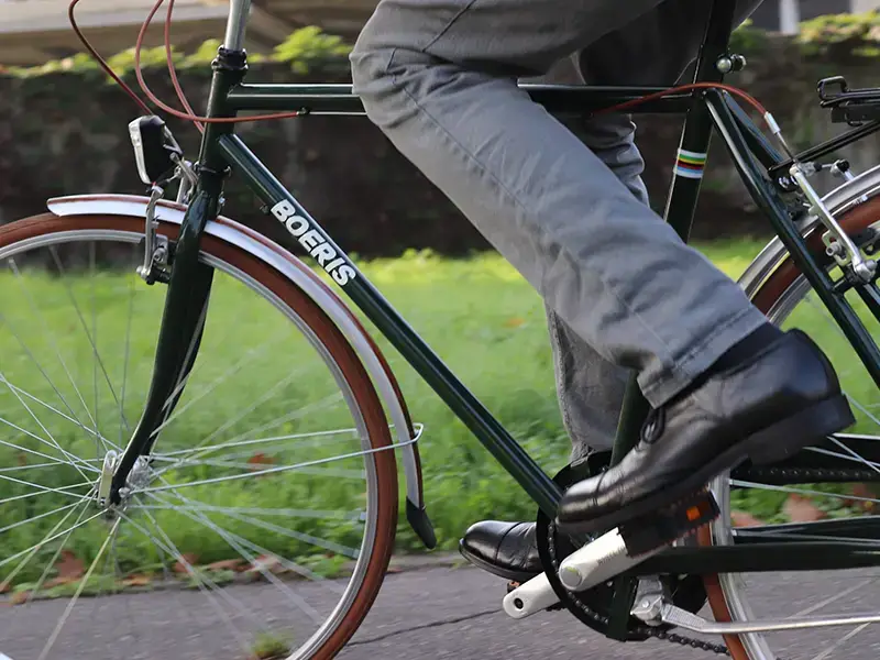 Fotografia ravvicinata di una city bike retrò colore verdone e marrone di Boeris Bikes Torino in un parco cittadino