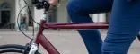 Dettaglio di una city bike business Boeris Bikes Torino amaranto in piazza Castello a Torino guidata da un ragazzo vestito con completo elegante blu