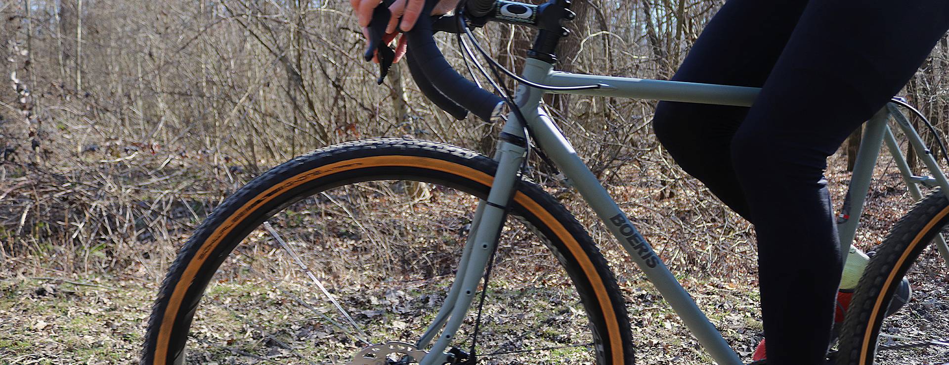 dettaglio di una Gravel Bike serie x-performancegrigia fotografata in un bosco con ciclista con pantaloni neri