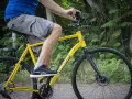 Ragazzo in sella ad una Trekking Bike Boeris Bike Torino gialla in un parco cittadino